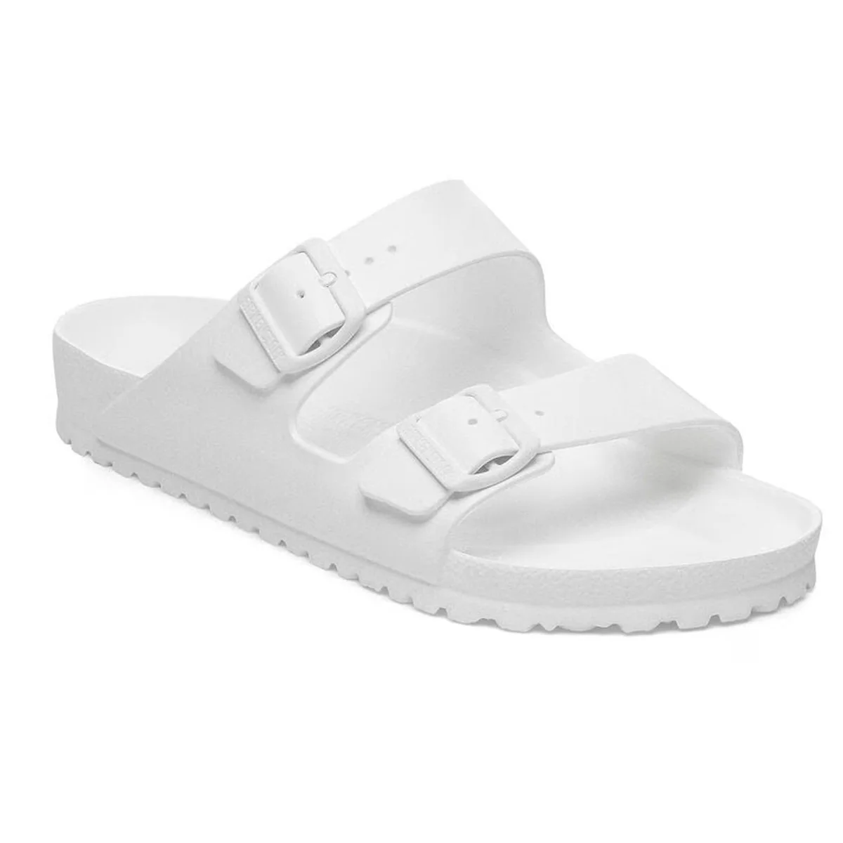 A white slide sandal with two adjustable straps and buckles, featuring a textured sole for grip.