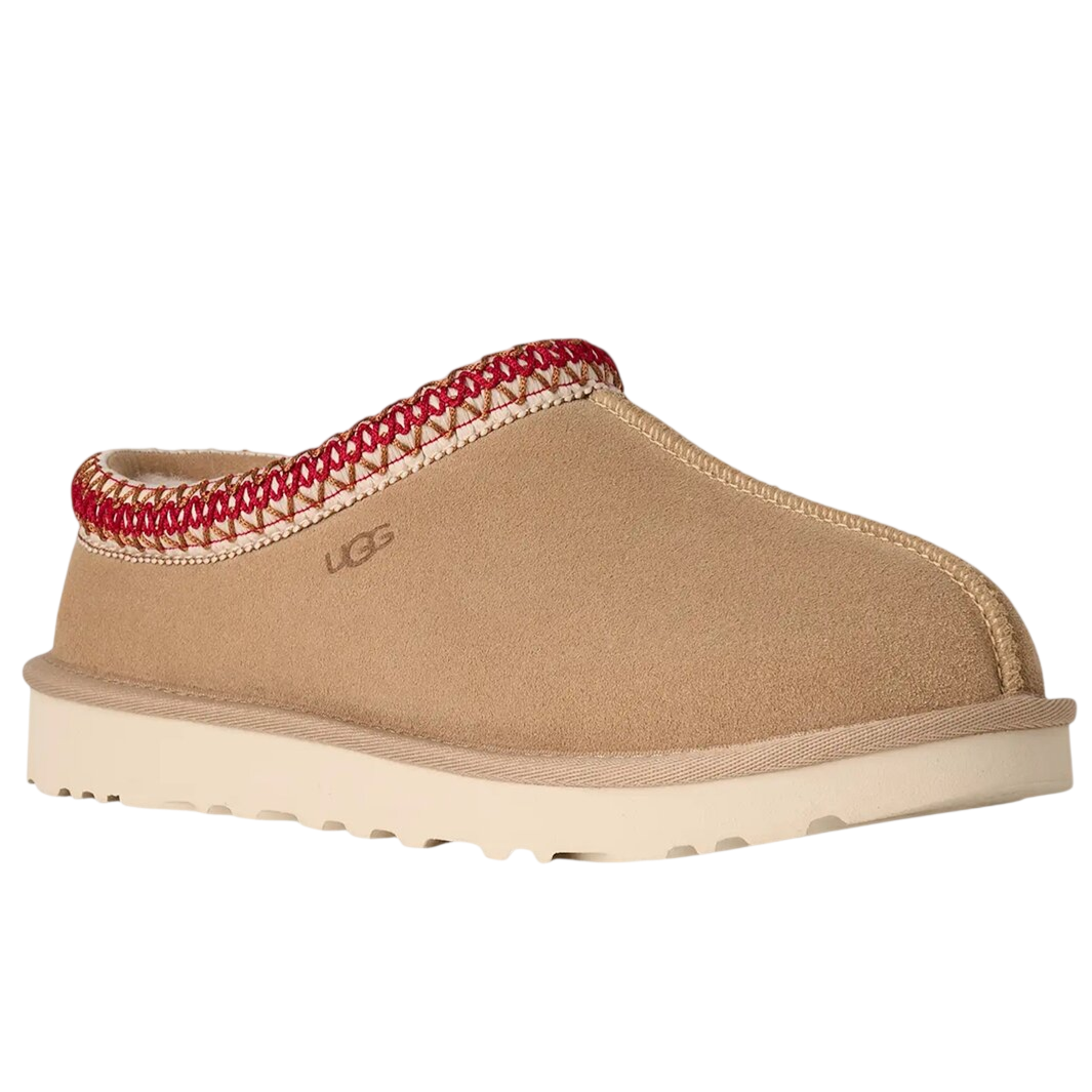 Tan suede slip-on shoe with a red-trimmed edge and a cream rubber sole. Brand logo is subtly embossed on the side.